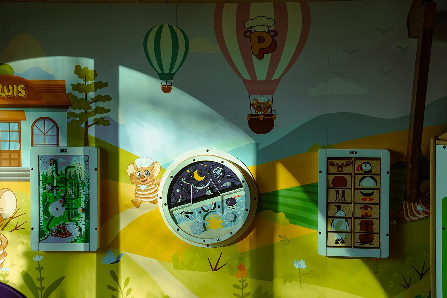 Speelwand met muurschildering, luchtballonnen en houten speelpaneeltjes