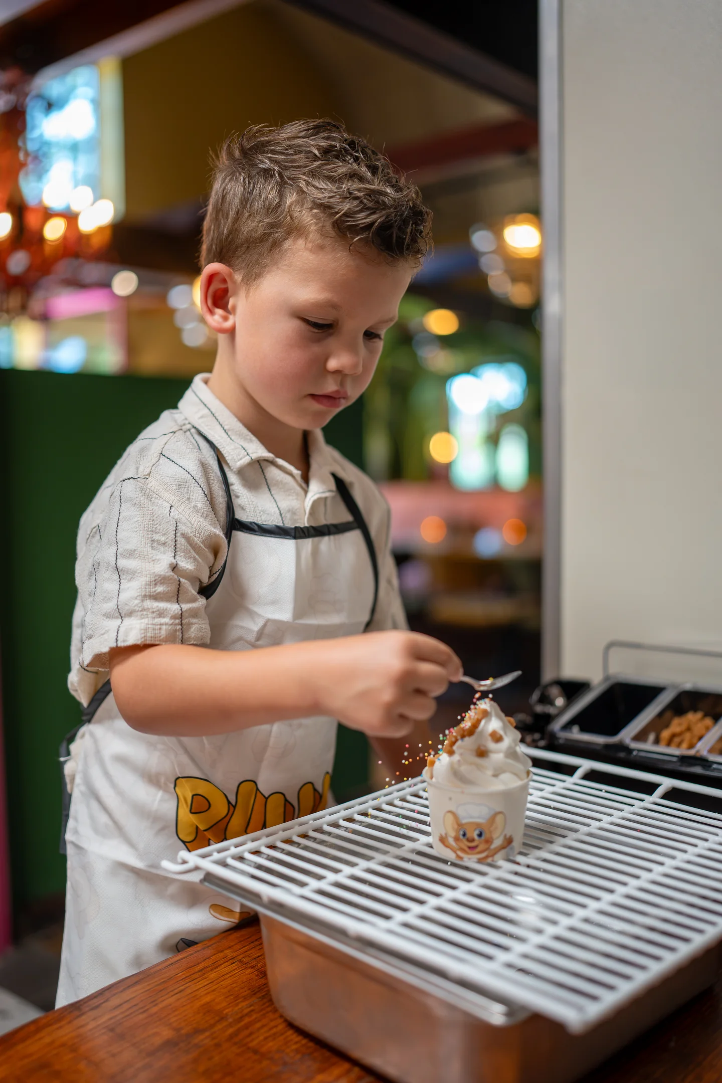 Kind versiert zelf een softijsje bij het ijsstation van Familierestaurant Pluis