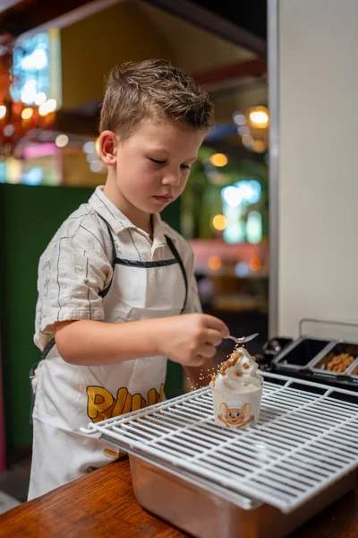 Kind versiert zelf een softijsje bij het ijsstation van Familierestaurant Pluis
