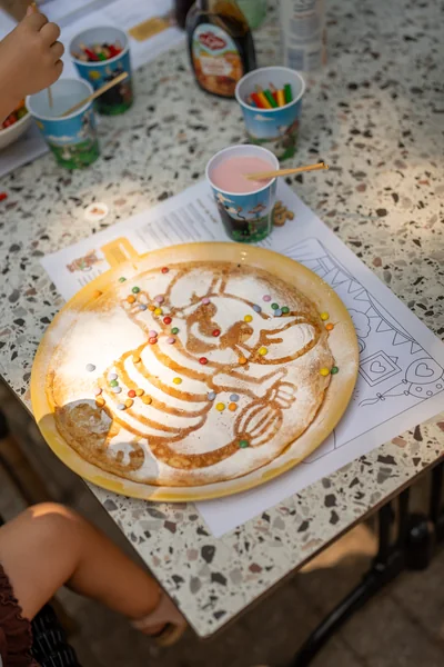 Pannenkoek met Pluis de Pannenkoekenmuis getekend in stroop en snoepjes
