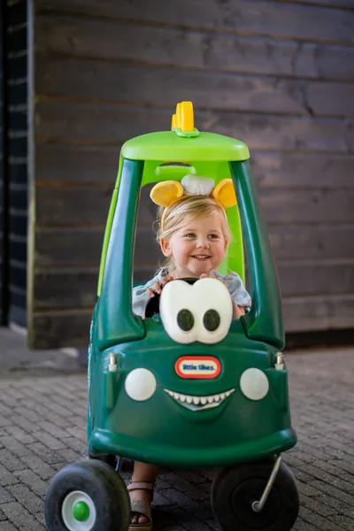 Peuter met muizenoortjes in een speelauto bij Familierestaurant Pluis