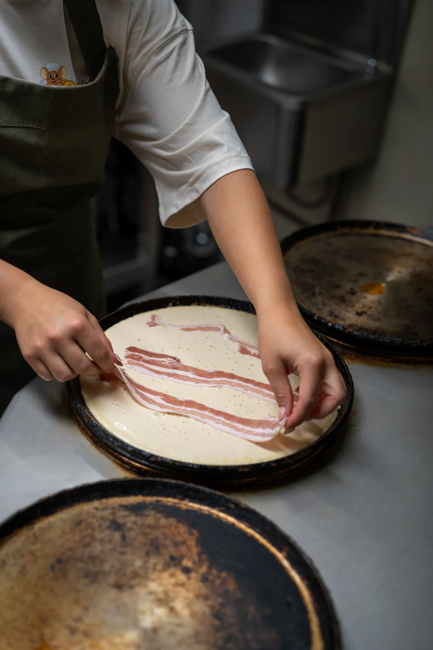Pannenkoek met spek wordt bereid in de keuken van Familierestaurant Pluis